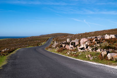 Road amidst landscape against blue sky