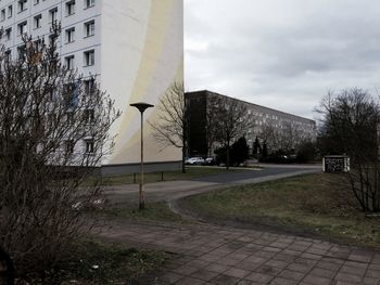 Road leading towards built structure against sky