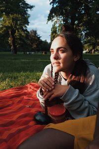 Close-up of young woman sitting on tree