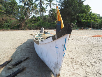 Boat moored on beach against sky