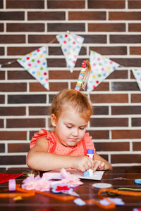 Portrait of girl sitting on table