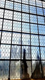 Midsection of man standing against sky seen through glass