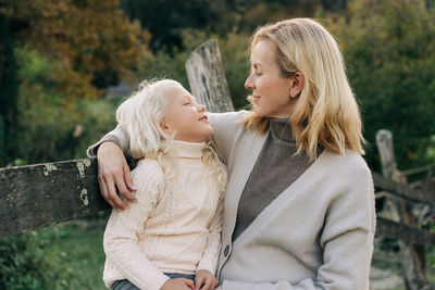 Mom with her little daughter on a walk outside on an autumn day.