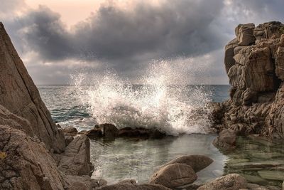 Close-up of waves splashing on shore against sky