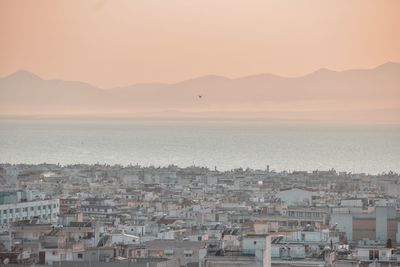 High angle view of townscape by sea against sky