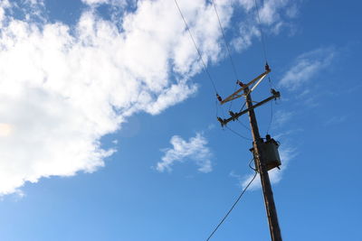 Low angle view of telephone pole against sky