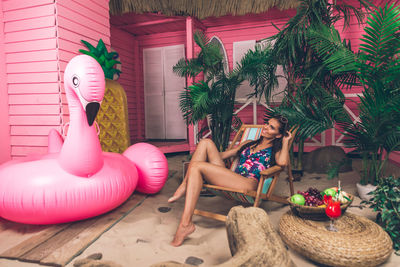 Woman sitting on potted plant in yard