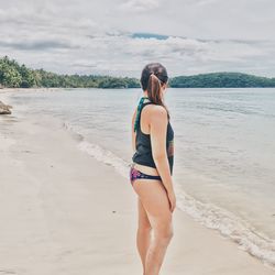 Rear view of young woman walking on beach