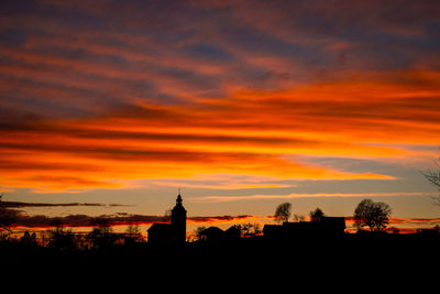 Silhouette buildings against sky during sunset