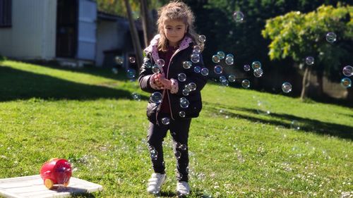 5 year old girl playing with soap bubbles