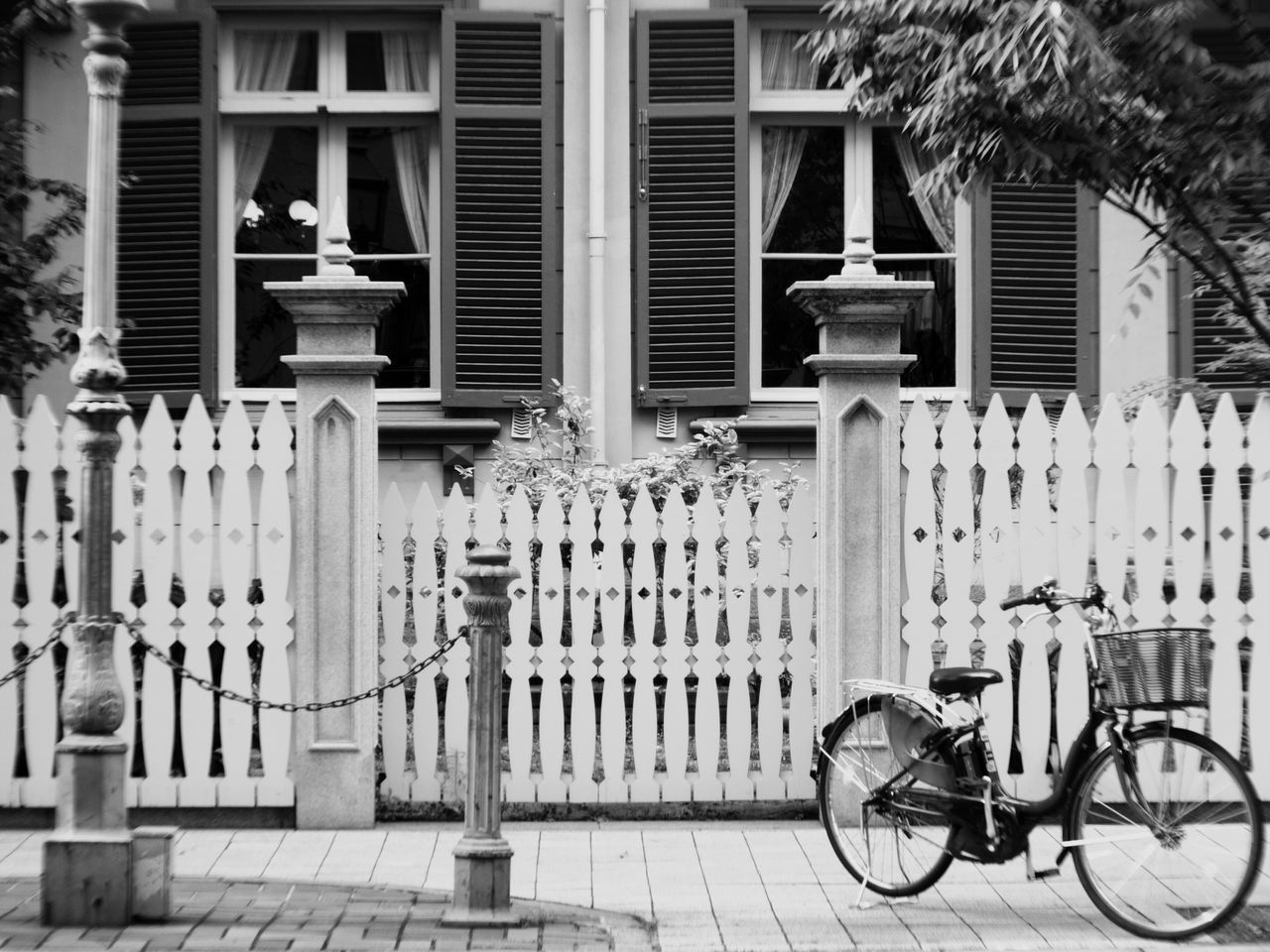 building exterior, architecture, built structure, bicycle, land vehicle, mode of transport, parked, transportation, stationary, city, tree, gate, parking, outdoors, railing, day, building, house, street light, residential building