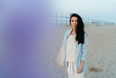 Beautiful young woman standing at beach