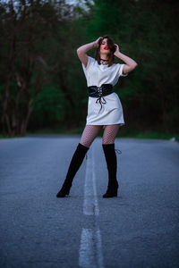 Full length portrait of woman standing on road