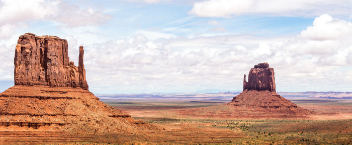 Rock formations on landscape against cloudy sky