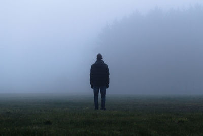 Rear view of man standing on field