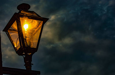 Low angle view of illuminated street light against sky at sunset