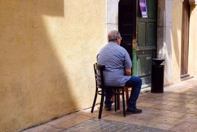 Rear view of man sitting outdoors