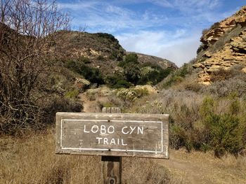 Information sign on landscape against sky