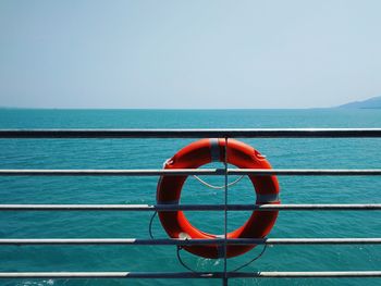 Red boat on sea against clear sky