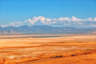 Scenic view of landscape and mountains against blue sky