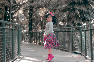 Cute girl jumping on bridge