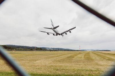 Low angle view of airplane flying against sky