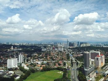 High angle view of cityscape against cloudy sky