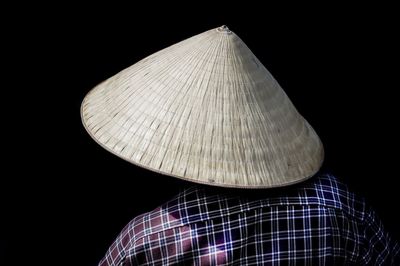 Rear view of man wearing hat against black background