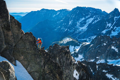 High angle view of people on rock against snowcapped mountains