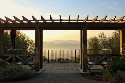 Footbridge against sky during sunset