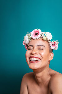 Portrait of a smiling young woman against blue background