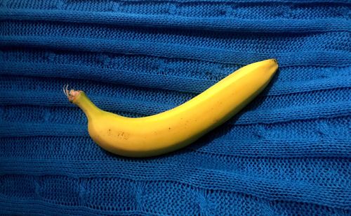 Close-up of yellow fruit on blue surface