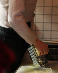 Midsection of man standing in kitchen at home