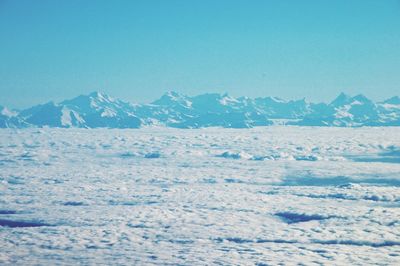 Scenic view of snow mountains against blue sky