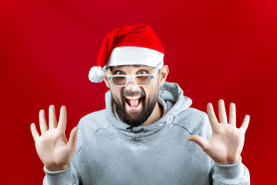 Portrait of man wearing sunglasses against red background