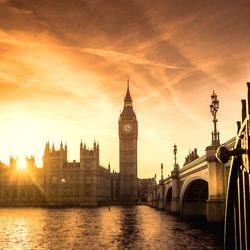 Westminster palace and bridge with thames river in city against sky