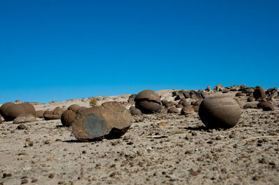 Rocks in desert against clear blue sky