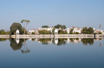 Scenic view of lake by building against clear sky