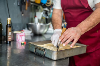 Close up of hands with knife cutting pastry in a pan in belgrade serb