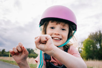 Happy portrait of a young girl with a helmet on playing outside