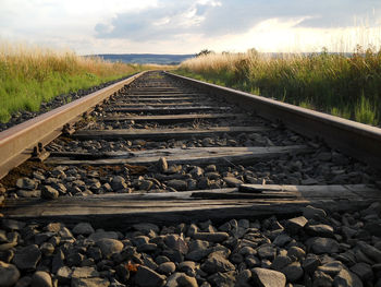 Railroad track against cloudy sky