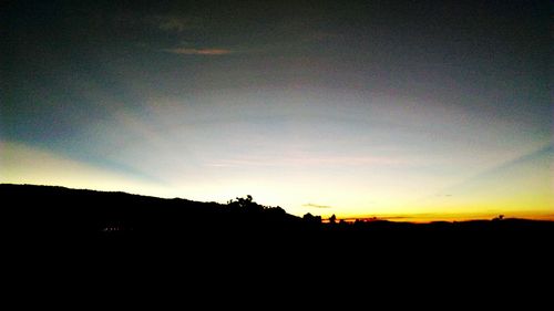 Silhouette landscape against sky at sunset