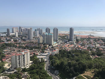 High angle view of cityscape by sea against clear sky