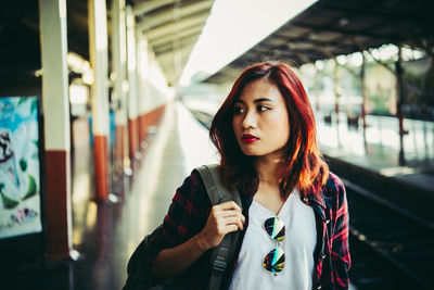 Young woman standing at railroad station platform
