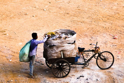 Rear view of people working with bicycle