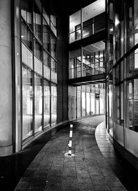 Empty footpath amidst buildings in city