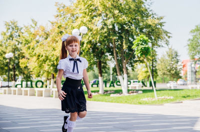 Portrait of young woman walking on road