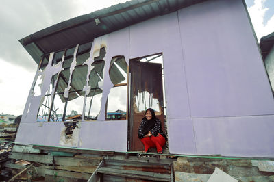 Rear view of woman standing against building