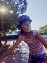 Portrait of smiling young woman against trees