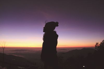 Silhouette woman standing against sky during sunset